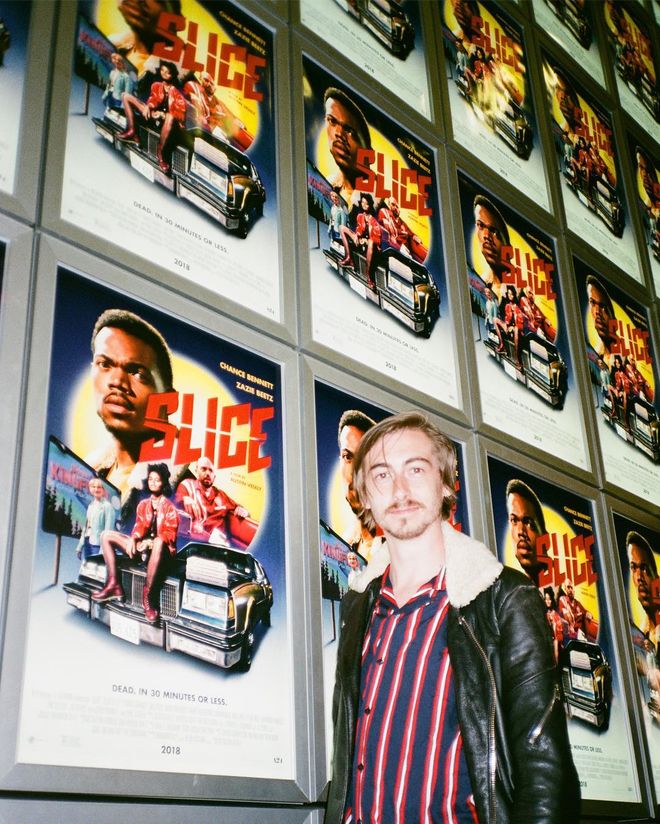 IMAGE: Austin Vesely in front of posters at the premiere of Slice posters